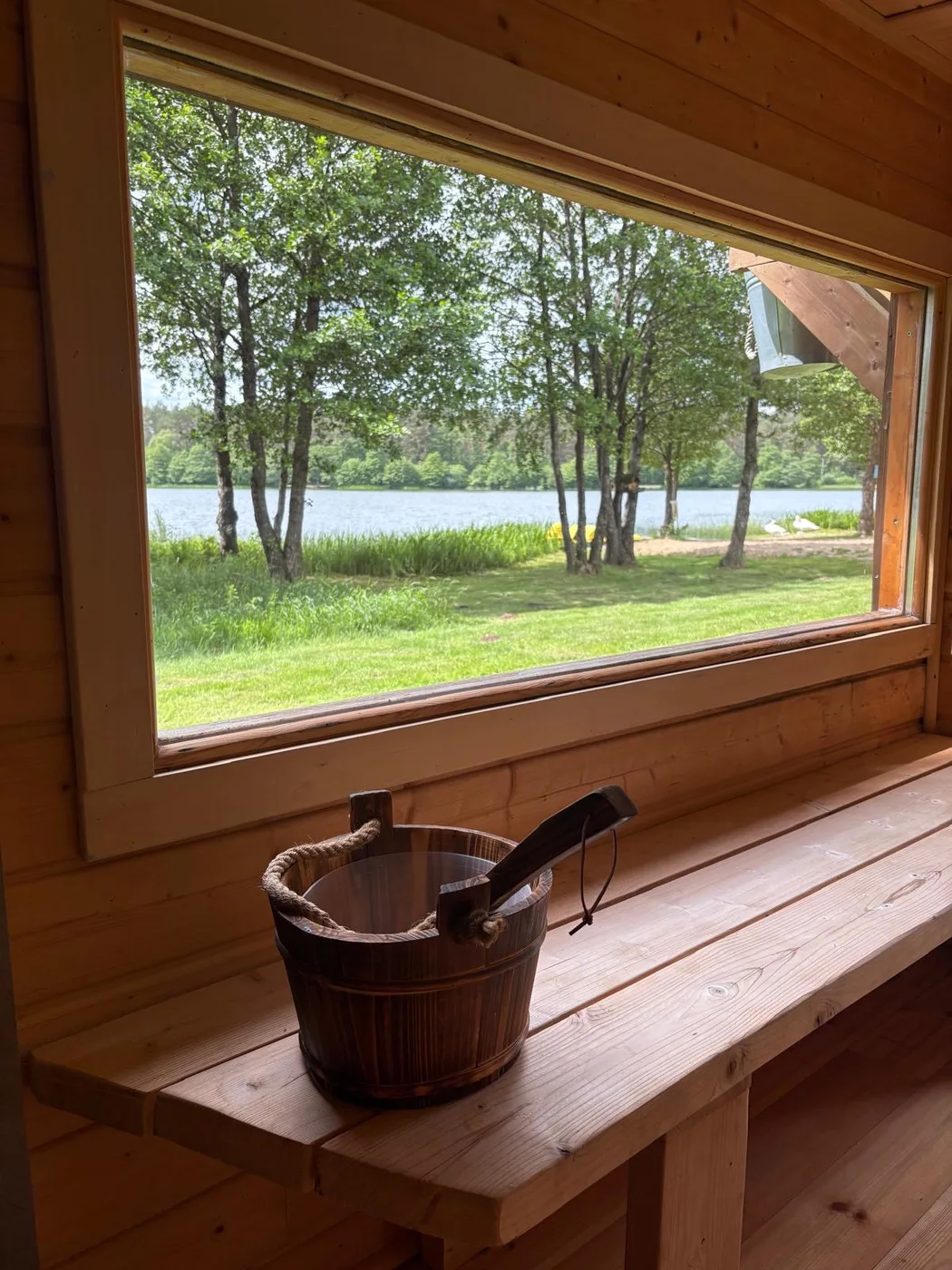Sauna Leonówki nad samym brzegiem jeziora — widok na taflę wody przez panoramiczne okno
